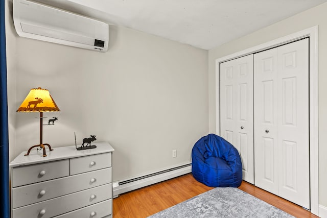 sitting room featuring light wood-style floors, a wall mounted AC, and baseboard heating