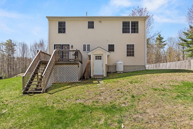 rear view of house with stairway, a deck, fence, and a lawn