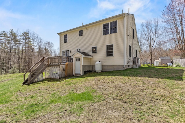 back of house featuring stairs, a lawn, a wooden deck, and a shed