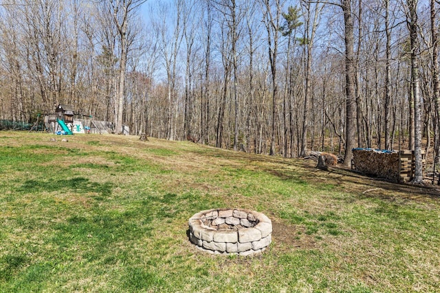 view of yard featuring a playground and an outdoor fire pit