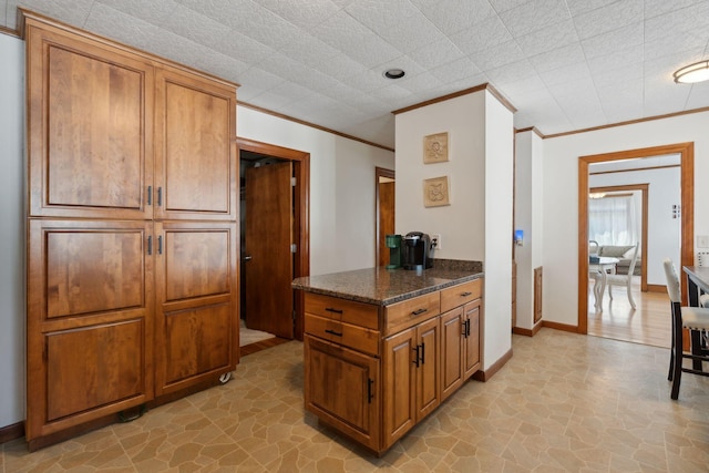 23-25 Deerfield Rd, Portland, ME 04101 - kitchen featuring brown cabinets, ornamental molding, dark stone countertops, and baseboards