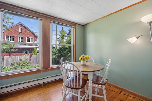 23-25 Deerfield Rd, Portland, ME 04101 - dining space with a baseboard radiator, ornamental molding, wood finished floors, and baseboards