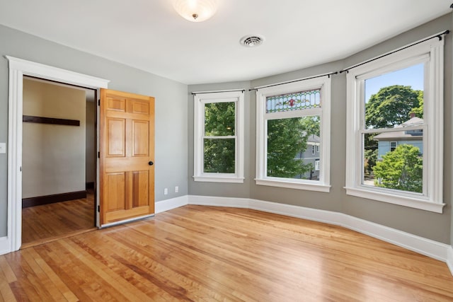 23-25 Deerfield Rd, Portland, ME 04101 - unfurnished bedroom with light wood finished floors, multiple windows, and baseboards