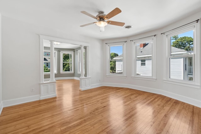 23-25 Deerfield Rd, Portland, ME 04101 - unfurnished room with decorative columns, light wood-style flooring, baseboards, and plenty of natural light