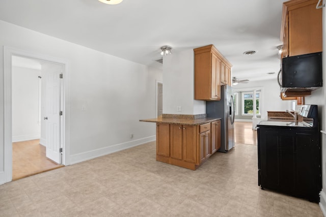 23-25 Deerfield Rd, Portland, ME 04101 - kitchen with brown cabinetry, stainless steel refrigerator with ice dispenser, light flooring, and dark countertops