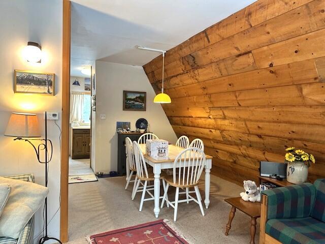 dining space featuring carpet flooring and vaulted ceiling