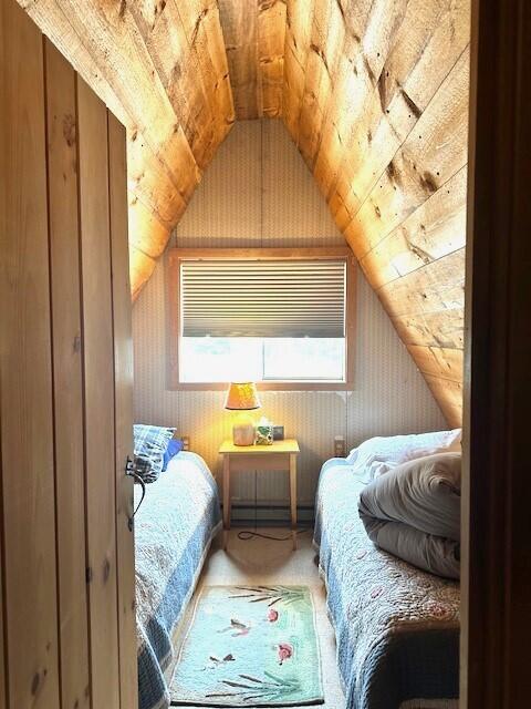 bedroom with lofted ceiling, a baseboard heating unit, and wooden ceiling