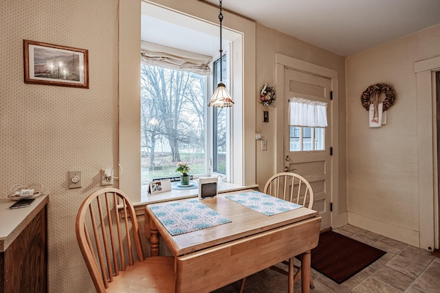 dining area with baseboards and wallpapered walls