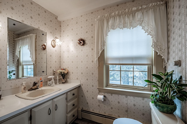 half bath with baseboard heating, wallpapered walls, toilet, and vanity
