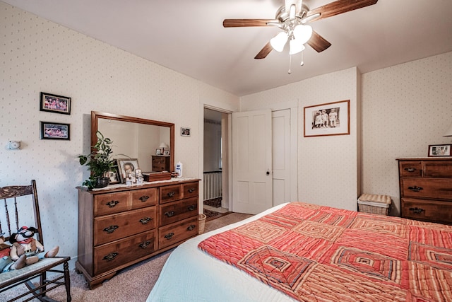 bedroom featuring a ceiling fan, wallpapered walls, and light colored carpet