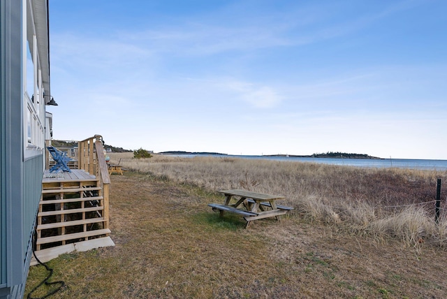 view of yard with a deck with water view and stairway