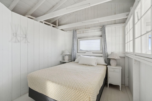 bedroom with wooden walls, wood ceiling, lofted ceiling with beams, and wood finished floors