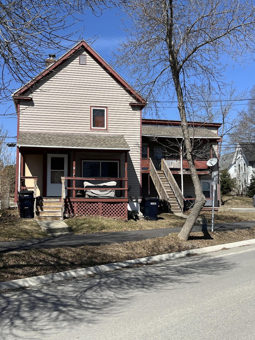 view of front of home with covered porch, stairway, and a chimney