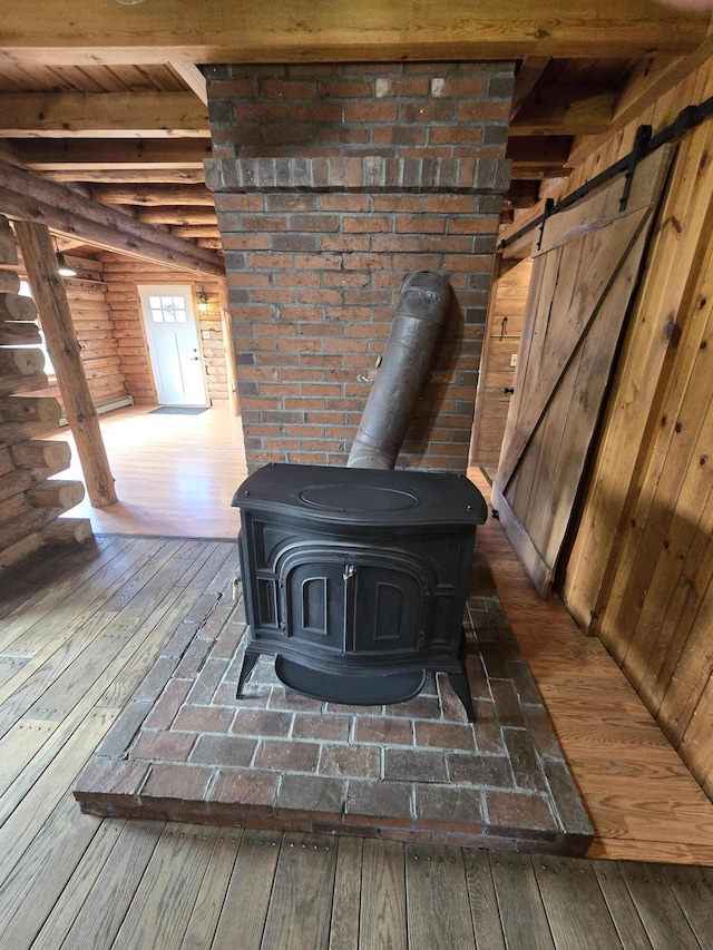 369 Hawes Bridge Rd, Prospect, ME 04981 - detailed view of a wood stove, wood finished floors, beamed ceiling, and a barn door