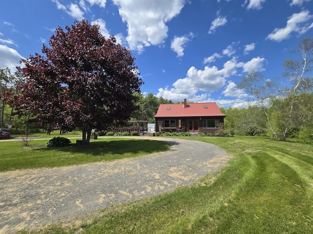 369 Hawes Bridge Rd, Prospect, ME 04981 - view of front of home featuring a front yard, curved driveway, metal roof, and a chimney