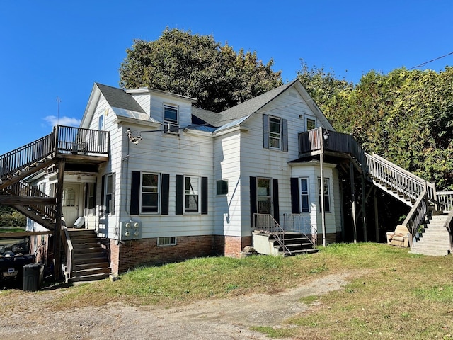 view of front of property with roof with shingles and stairway