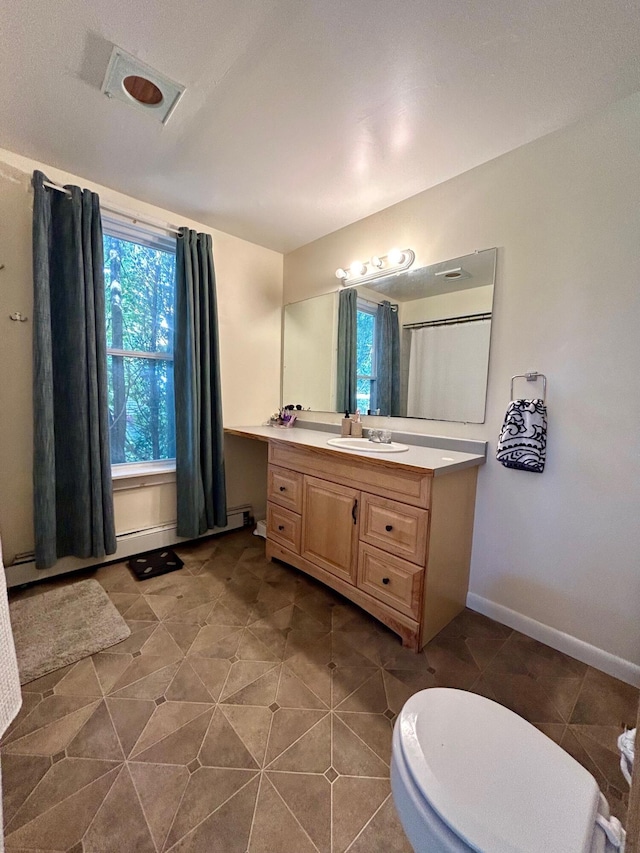 bathroom featuring a wealth of natural light, tile patterned floors, vanity, and baseboards
