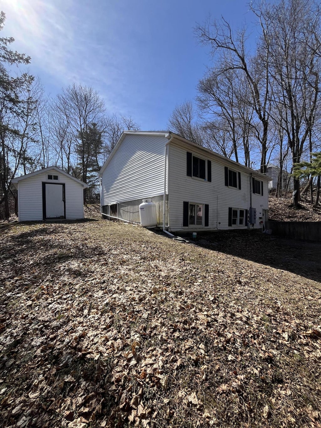 back of property featuring an outbuilding and a shed