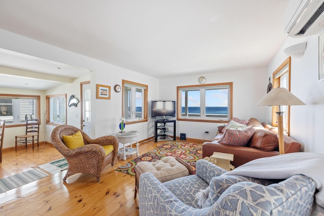 347 Webhannet Dr, Wells, ME 04090 - living area featuring plenty of natural light, light wood finished floors, baseboards, and a wall unit AC