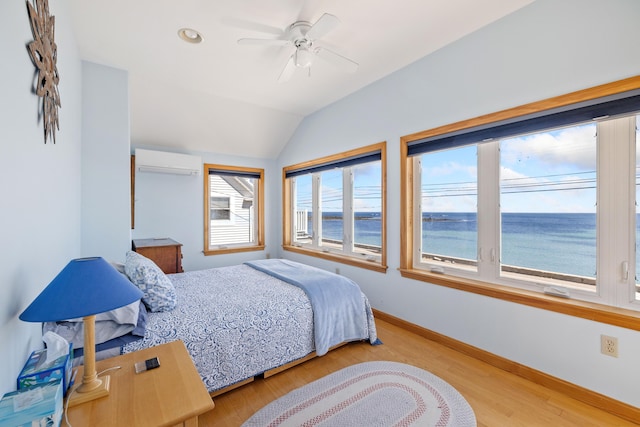 347 Webhannet Dr, Wells, ME 04090 - bedroom with a wall mounted AC, baseboards, lofted ceiling, a water view, and wood finished floors