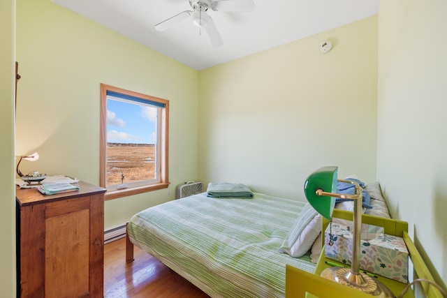347 Webhannet Dr, Wells, ME 04090 - bedroom with a baseboard radiator, a ceiling fan, and wood finished floors