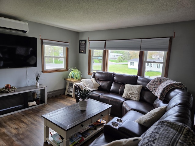 134 Minuteman Dr, Millinocket, ME 04462 - living area featuring a wall unit AC, dark wood-type flooring, a textured ceiling, and baseboard heating