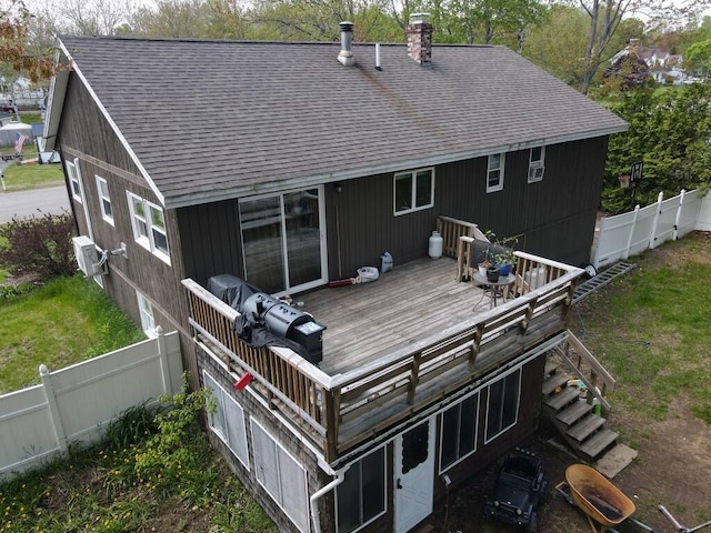 134 Minuteman Dr, Millinocket, ME 04462 - rear view of house with a wooden deck, a fenced backyard, a shingled roof, a chimney, and stairs