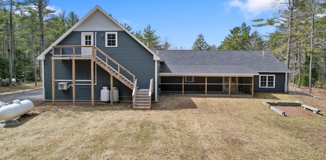 rear view of house with a shingled roof and stairway