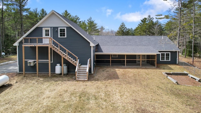 rear view of property featuring roof with shingles and stairway