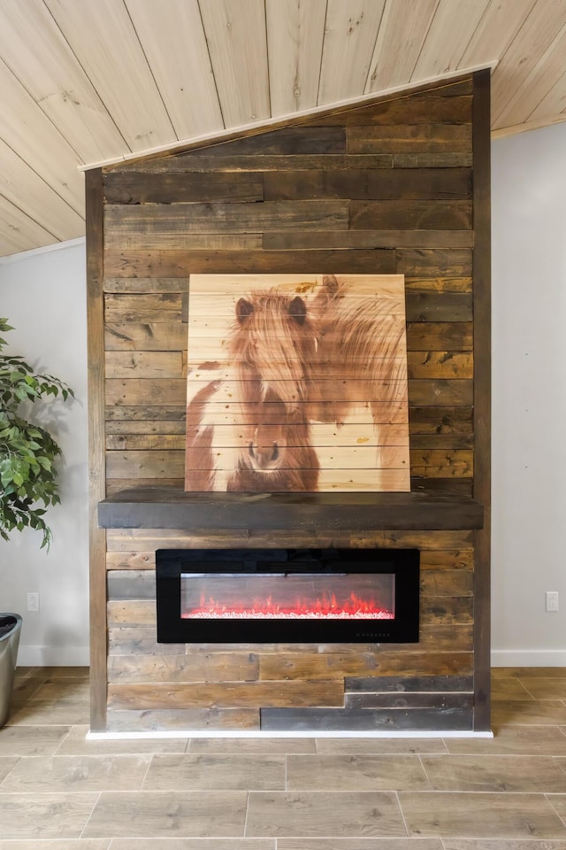 interior details with wood walls, wood finish floors, a glass covered fireplace, and wood ceiling