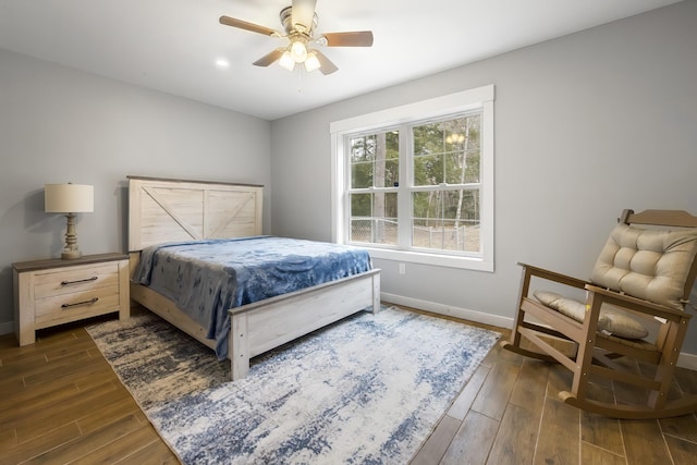 bedroom with ceiling fan, dark wood-style flooring, and baseboards
