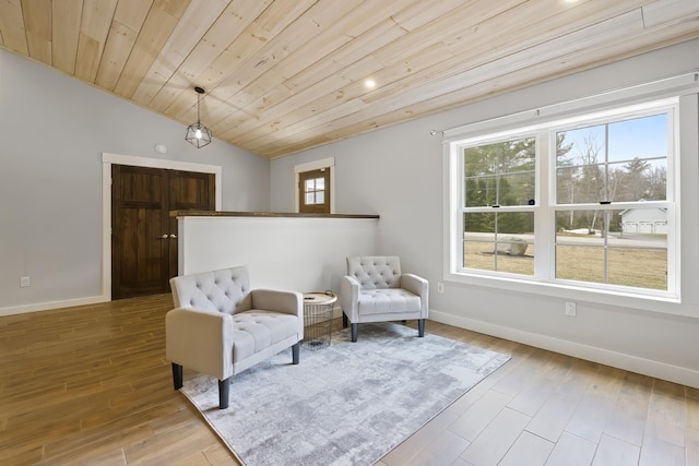 sitting room with a healthy amount of sunlight, baseboards, wood finished floors, and lofted ceiling