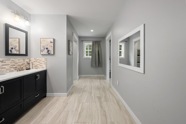 hallway featuring a sink and baseboards