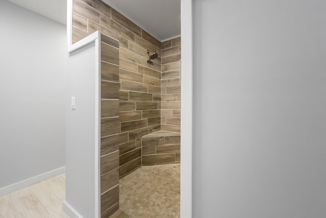 bathroom featuring baseboards and a tile shower