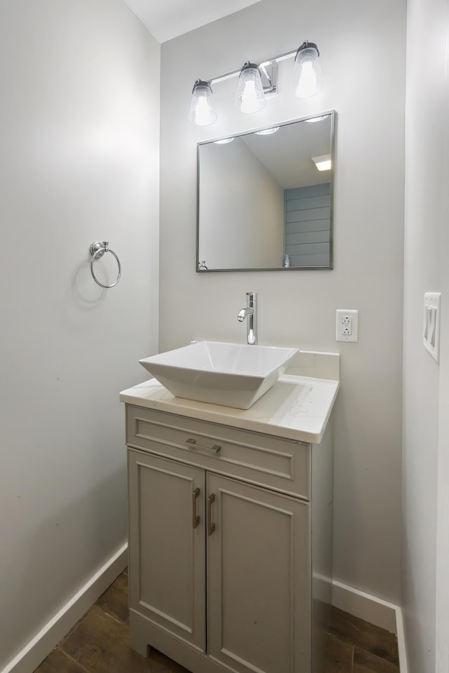bathroom with vanity, baseboards, and wood finished floors