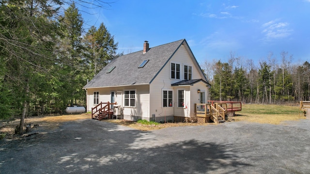 573 Exeter Rd, Corinth, ME 04427 - view of front of home with a chimney, a deck, and roof with shingles