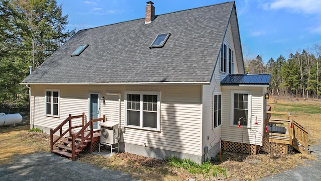 573 Exeter Rd, Corinth, ME 04427 - view of front facade featuring a chimney, a shingled roof, a cooling unit, and a deck