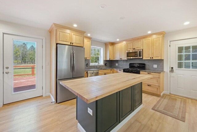 573 Exeter Rd, Corinth, ME 04427 - kitchen with stainless steel appliances, light brown cabinetry, butcher block counters, a sink, and decorative backsplash