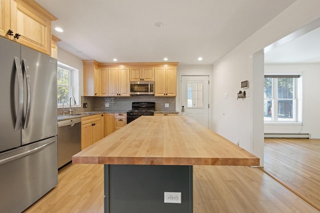 573 Exeter Rd, Corinth, ME 04427 - kitchen with stainless steel appliances, a sink, light brown cabinets, a baseboard heating unit, and butcher block counters