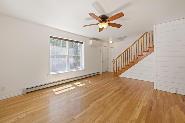 573 Exeter Rd, Corinth, ME 04427 - unfurnished living room featuring a baseboard heating unit, a wall mounted air conditioner, stairway, wood finished floors, and ceiling fan