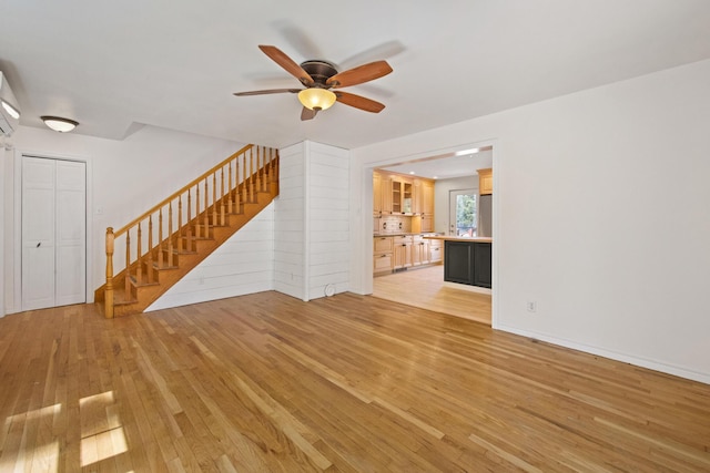573 Exeter Rd, Corinth, ME 04427 - unfurnished living room with light wood-type flooring, ceiling fan, and stairs