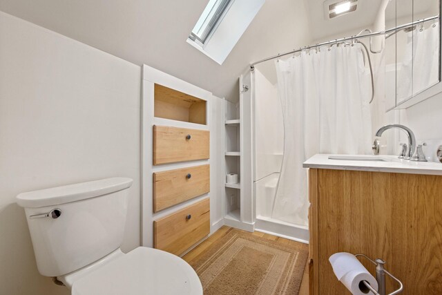 573 Exeter Rd, Corinth, ME 04427 - bathroom with a skylight, vanity, toilet, a shower with shower curtain, and wood finished floors