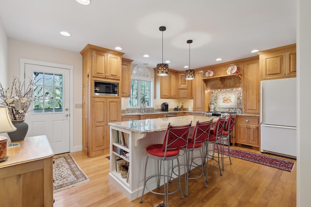 kitchen featuring freestanding refrigerator, open shelves, a kitchen island, stainless steel range oven, and built in microwave