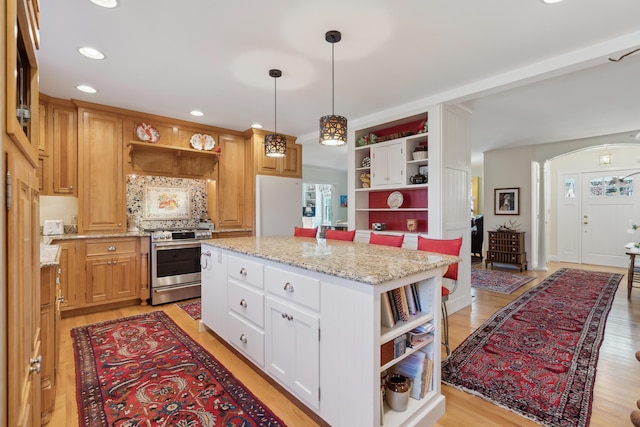 kitchen with open shelves, a center island, white cabinetry, electric stove, and hanging light fixtures