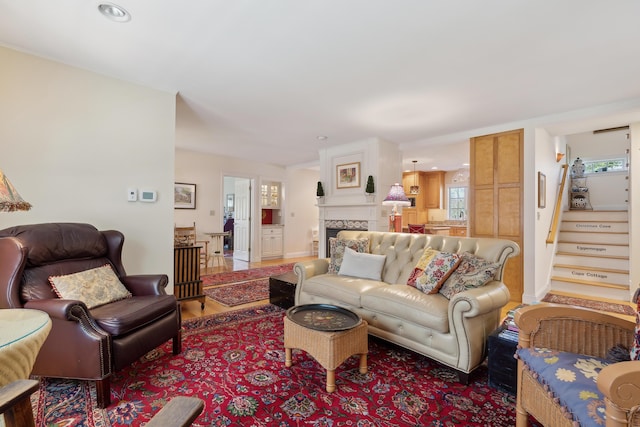 living area with recessed lighting, baseboards, stairs, and wood finished floors