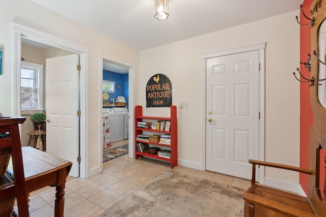 interior space with baseboards, washer / dryer, and light tile patterned floors