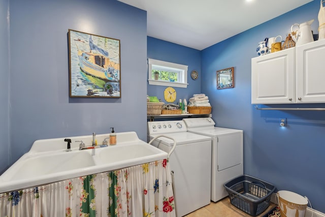 laundry area with cabinet space, separate washer and dryer, a sink, and light tile patterned floors