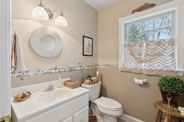 half bathroom featuring vanity and toilet
