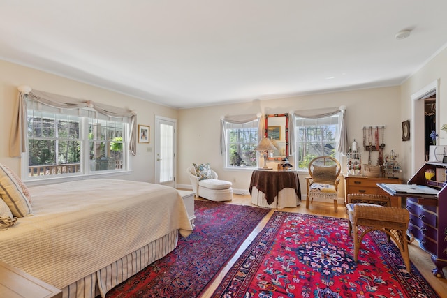 bedroom featuring ornamental molding and wood finished floors