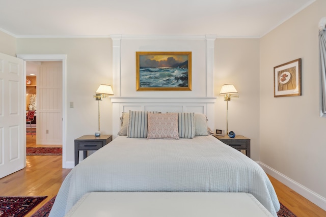 bedroom with crown molding, baseboards, and light wood-style flooring